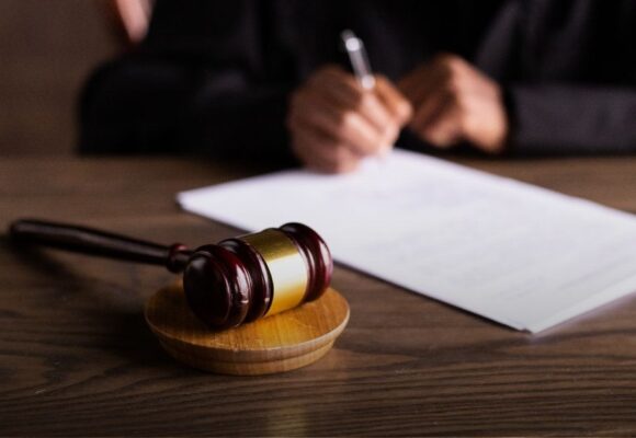 Image of a gavel and a judge writing an injunction