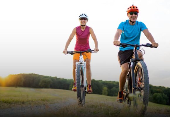An image of an older couple riding bikes