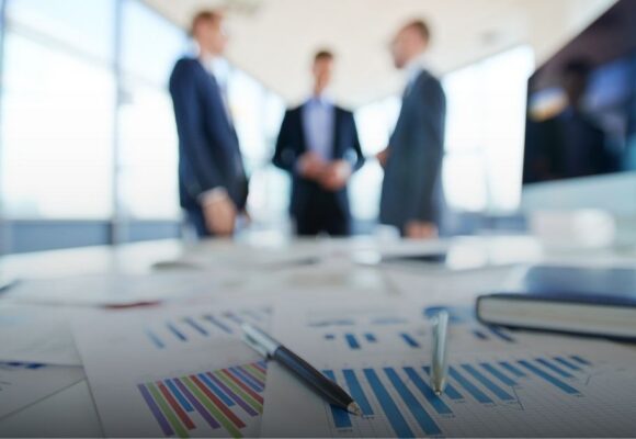 Image of business people talking near a table full of charts