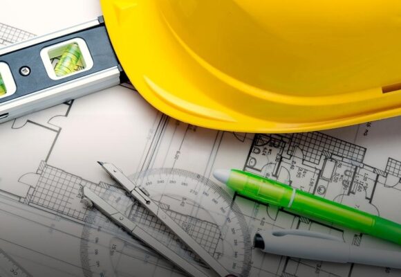 Image of blueprints with a hard hat and other tools