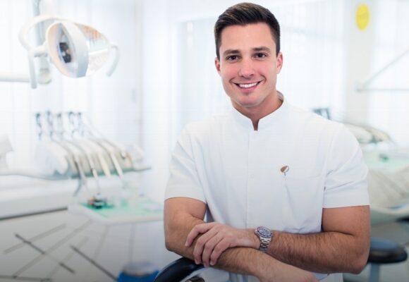 Image of a young dentist standing in an exam room