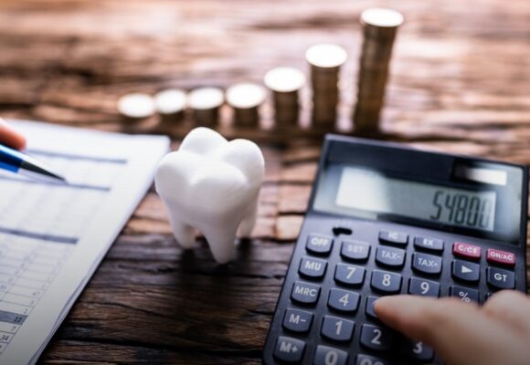 Image of a desk with a tooth paperweight and a calculator with papers