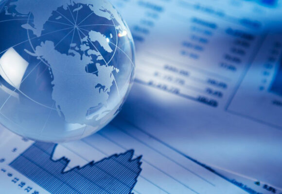 Image of a glass globe paperweight on top of financial charts