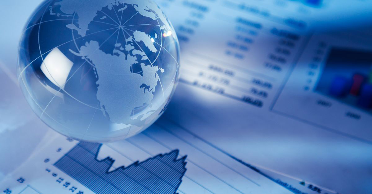 Image of a glass globe paperweight on top of financial charts