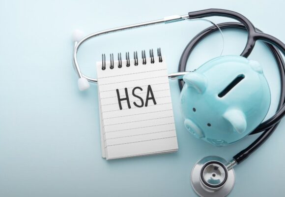 An image of a piggy bank, a stethoscope, and a pad of paper with 'HSA' written on it