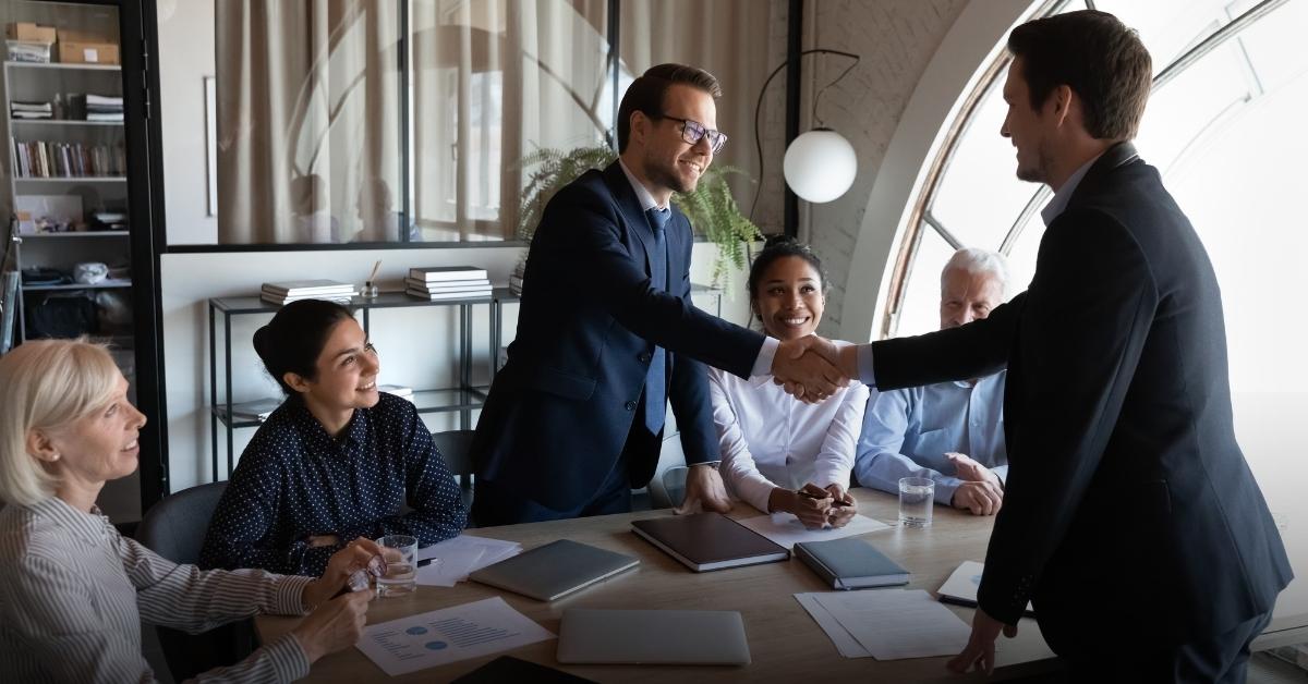 Image of a table of employees welcoming a new hire