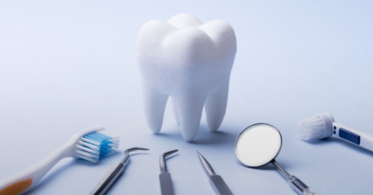 Image of a giant prop tooth and dental hygiene tools
