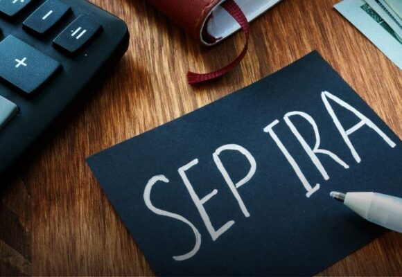 Image of a desk with a calculator and keyboard, with a note that says 'SEP-IRA'