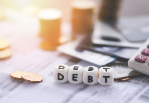 Image of a calculator and money with the word 'debt'