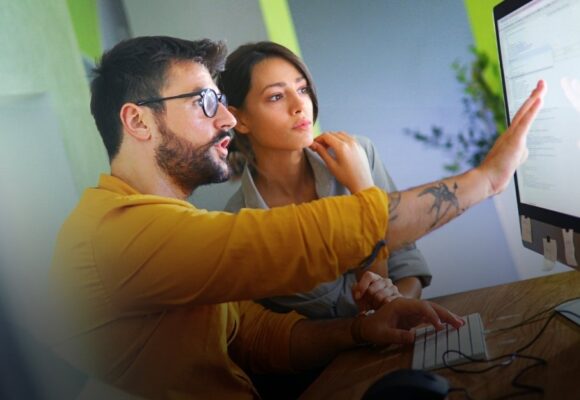 Image of two people at a computer doing research and development