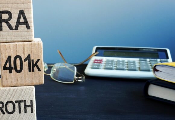 Image of a desk with blocks that say 'IRA' '401k' and 'ROTH'