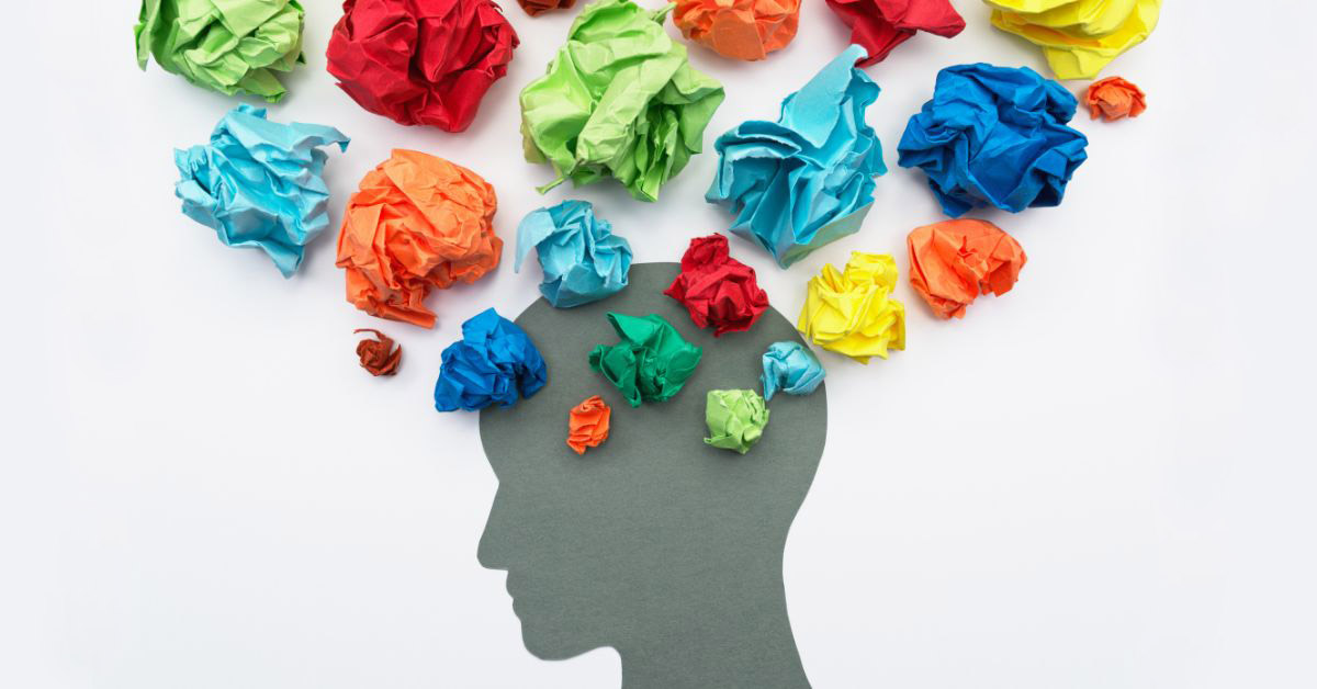 Image of a person's silhouette with colorful, balled-up papers